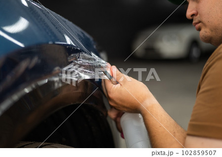 The master in the car service cuts the protective cutter. The master in the car service cuts the protective cutter. 102859507