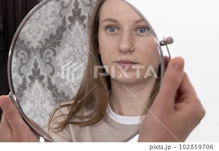 Portrait Of Caucasian Woman After Eyelash Lamination Procedure Looking At Own Reflection In Mirror. Horizontal Plane Portrait Of Caucasian Woman After Eyelash Lamination Procedure Looking At Own Reflection In Mirror. Horizontal Plane 102859706