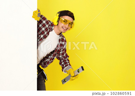 smiling professional builder in work clothes in helmet with level . 102860591