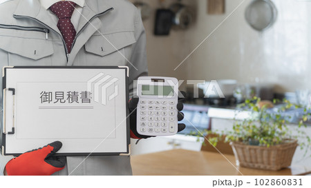 リビング・キッチンで電卓と見積書を持つ作業服の男性 リビング・キッチンで電卓と見積書を持つ作業服の男性 102860831