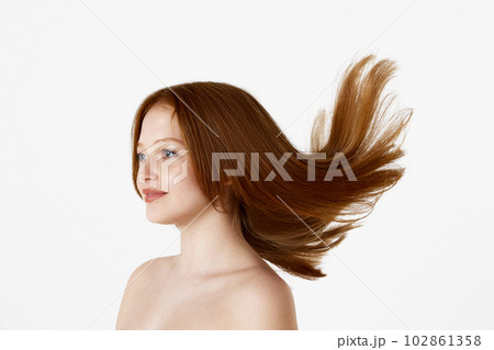 Side view portrait of young beautiful redhead girl with well-kept straight hair posing against white studio background Side view portrait of young beautiful redhead girl with well-kept straight hair posing against white studio background 102861358