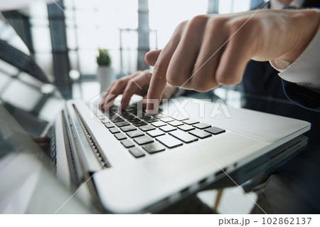 Young man presses his finger on the computer at the table in the office, close-up. 102862137