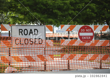 Yellow protective fence barrier at street construction site. Warning road sign about utility work 102862841