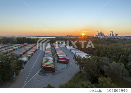 View from above of production line factory with large cargo container yard with rows of shipping containers for industrial products delivery. International trade concept View from above of production line factory with large cargo container yard with rows of shipping containers for industrial products delivery. International trade concept 102862946