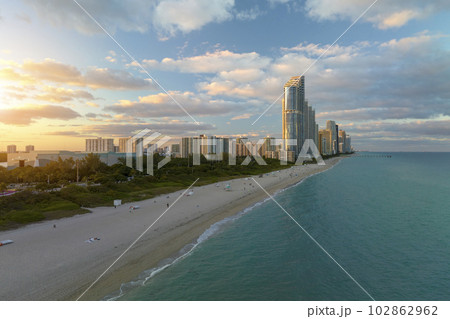 View from above of luxurious highrise hotels and condos on Atlantic ocean shore in Sunny Isles Beach city in the evening. American tourism infrastructure in southern Florida 102862962