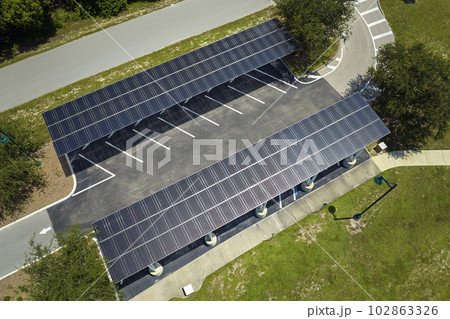 Solar panels installed over parking lot for parked cars for effective generation of clean energy 102863326