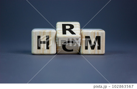 Human resource and capital management symbol. Turned wooden cubes and changed the word HCM to HRM. Beautiful grey background. Human resource and capital management and business concept. Copy space. 102863567