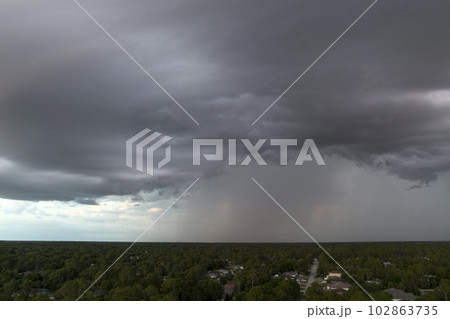Landscape of dark ominous clouds forming on stormy sky before heavy thunderstorm over rural town area Landscape of dark ominous clouds forming on stormy sky before heavy thunderstorm over rural town area 102863735