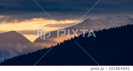 Colorful Puffy Clouds over the Mountain Landscape during dramatic Sunset. 102864892