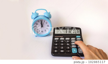 Text factor on calculator and clock on white background 102865117