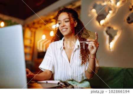 Young woman sitting at cafe making online shopping, using credit card and laptop. Online shopping 102866194