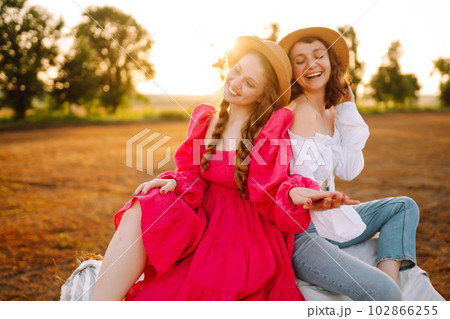 Two young women having fun near haystack. Fashion concept. Summer concept. 102866255