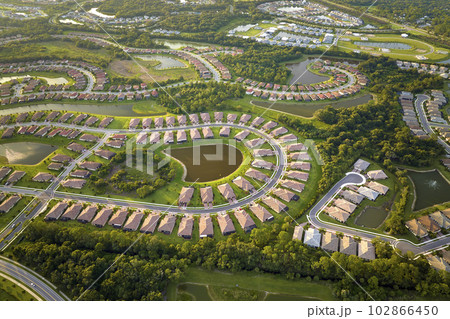 Aerial view of tightly located family houses with retention ponds to prevent flooding in Florida closed suburban area. Real estate development in american suburbs 102866450