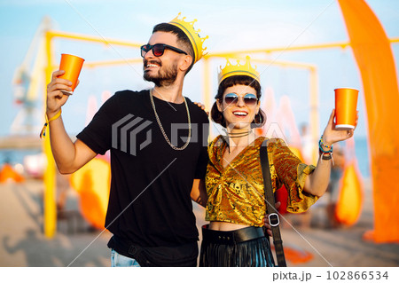 Lovely couple having fun at festival. Young friends with beer at beach party. Summer holiday, vacation. 102866534