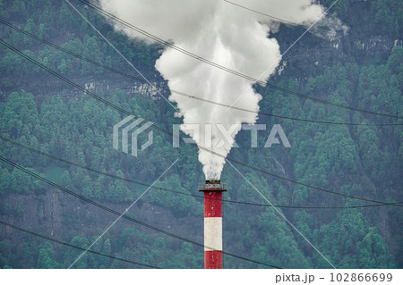 White smoke from the chimney of a manufacturing plant. 102866699