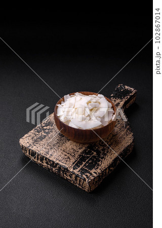 White dry coconut flakes in a wooden bowl prepared for making desserts 102867014