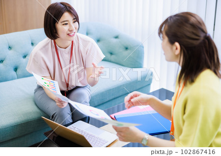 資料を見ながらミーティングする女性 102867416