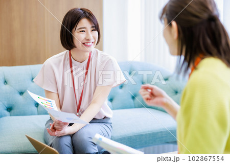 資料を見ながらミーティングする女性 102867554
