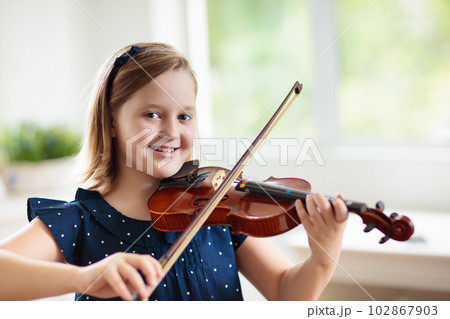 Child playing violin. Remote learning. 102867903