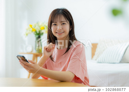 リビングでスマホを見る女性 リビングでスマホを見る女性 102868077