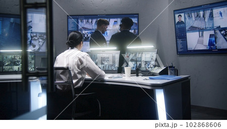 Multi ethnic employees talk in surveillance center Multi ethnic employees talk in surveillance center 102868606