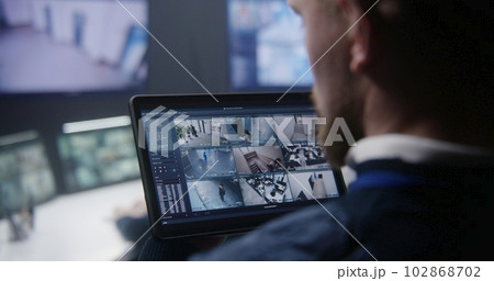 Security officer zoom CCTV cameras uses tablet Security officer zoom CCTV cameras uses tablet 102868702