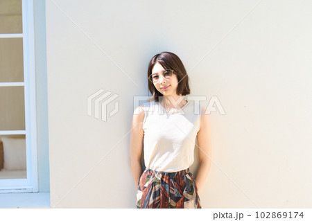屋外でサングラスをして光を浴びる女性 102869174