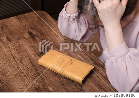 【長財布をみて頭を抱える主婦 長財布】 【長財布をみて頭を抱える主婦 長財布】 102869186