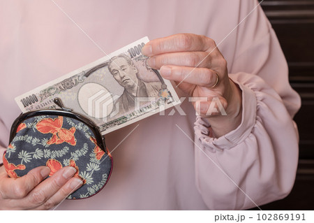 【がま口から10000円札を出す主婦】 102869191