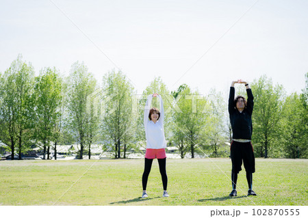 公園でストレッチする若いカップル 102870555