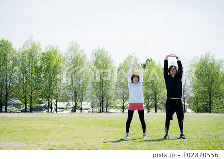 公園でストレッチする若いカップル 102870556