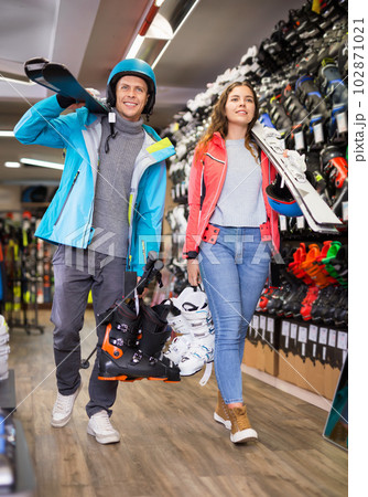 man and woman in helmets choosing sports equipment 102871021