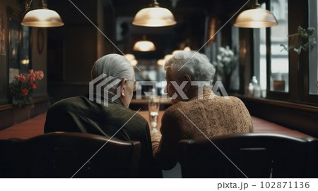 an elderly gray-haired couple, a man and a woman, sitting in a cafe.  102871136