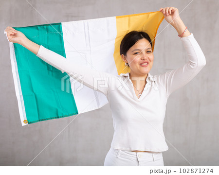 Pretty young female student holding Ireland flag in her hands 102871274