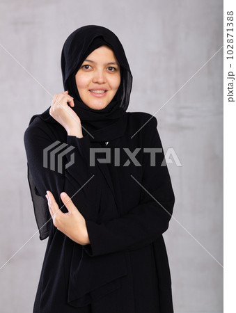 Portrait of young smiling woman in hijab posing in studio 102871388