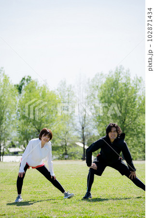 公園でストレッチする若いカップル 公園でストレッチする若いカップル 102871434