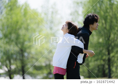 公園でストレッチする若いカップル 公園でストレッチする若いカップル 102871442