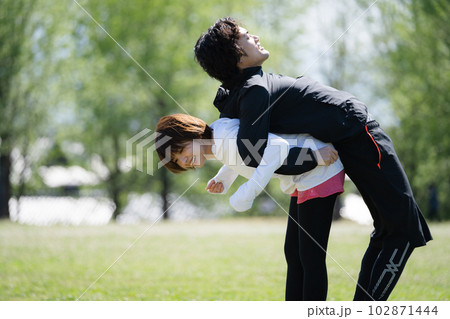 公園でストレッチする若いカップル 102871444