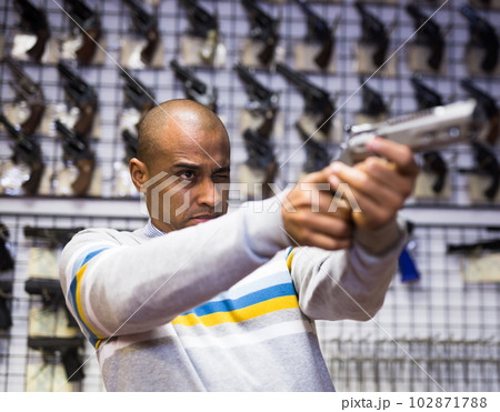 Choosing a revolver in gun shop closeup 102871788