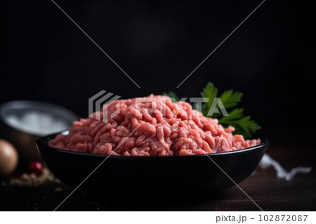 food background. Raw ground beef ready to be cooked on a plate 102872087