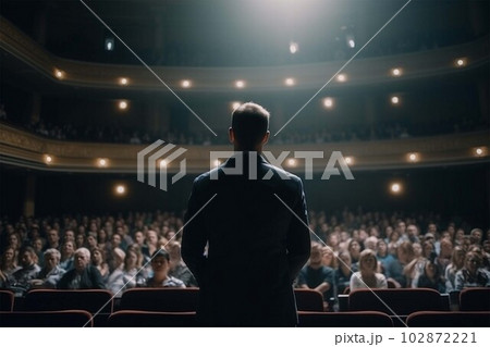 Motivational speaker with headset performing on stage, back view 102872221