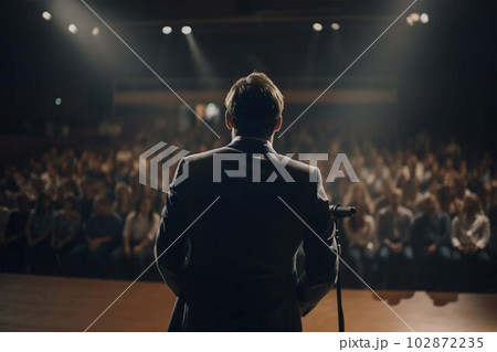 Motivational speaker with headset performing on stage, back view 102872235