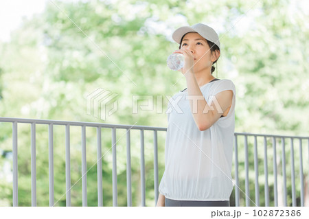 公園で水を飲みながら運動・ウォーキング・歩くアジア人女性 102872386