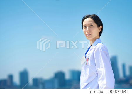 白衣の女性と晴天の街並み 102872643