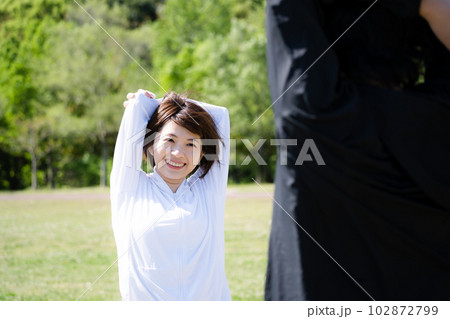公園でストレッチする若いカップル 102872799