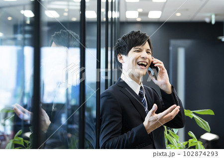 オフィスで電話をする若いビジネスマン 102874293