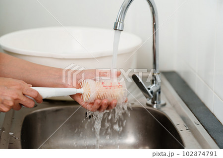 mother hand washing baby plastic milk bottle 102874791