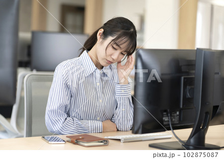 仕事中に頭痛が辛い女性 仕事中に頭痛が辛い女性 102875087