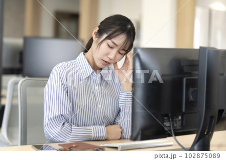 仕事中に頭痛が辛い女性 102875089
