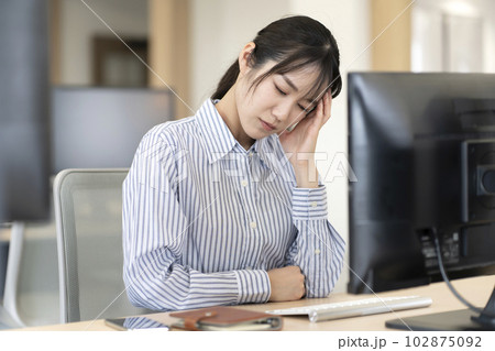 仕事中に頭痛が辛い女性 102875092
